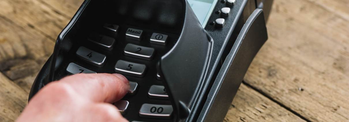 Man hand typing his PIN password at supermarket checkout in card