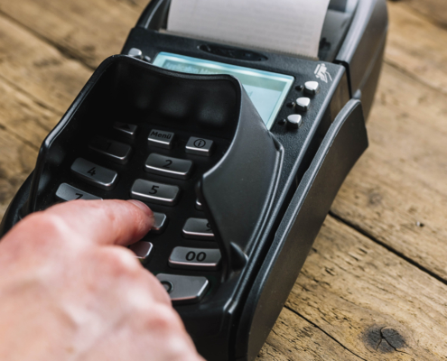 Man hand typing his PIN password at supermarket checkout in card
