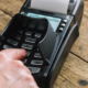 Man hand typing his PIN password at supermarket checkout in card